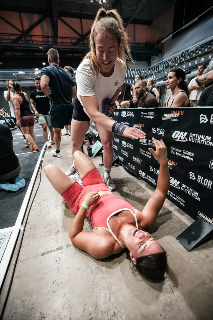 Coach gratuliert einer erschöpften Athletin nach dem Workout